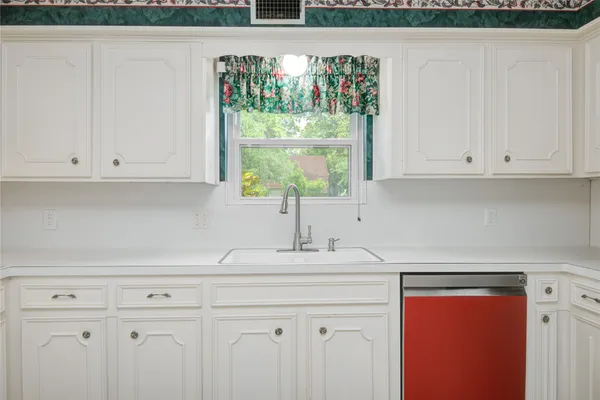 a kitchen with stainless steel appliances granite countertop a coffee maker on white cabinet and a granite counter top