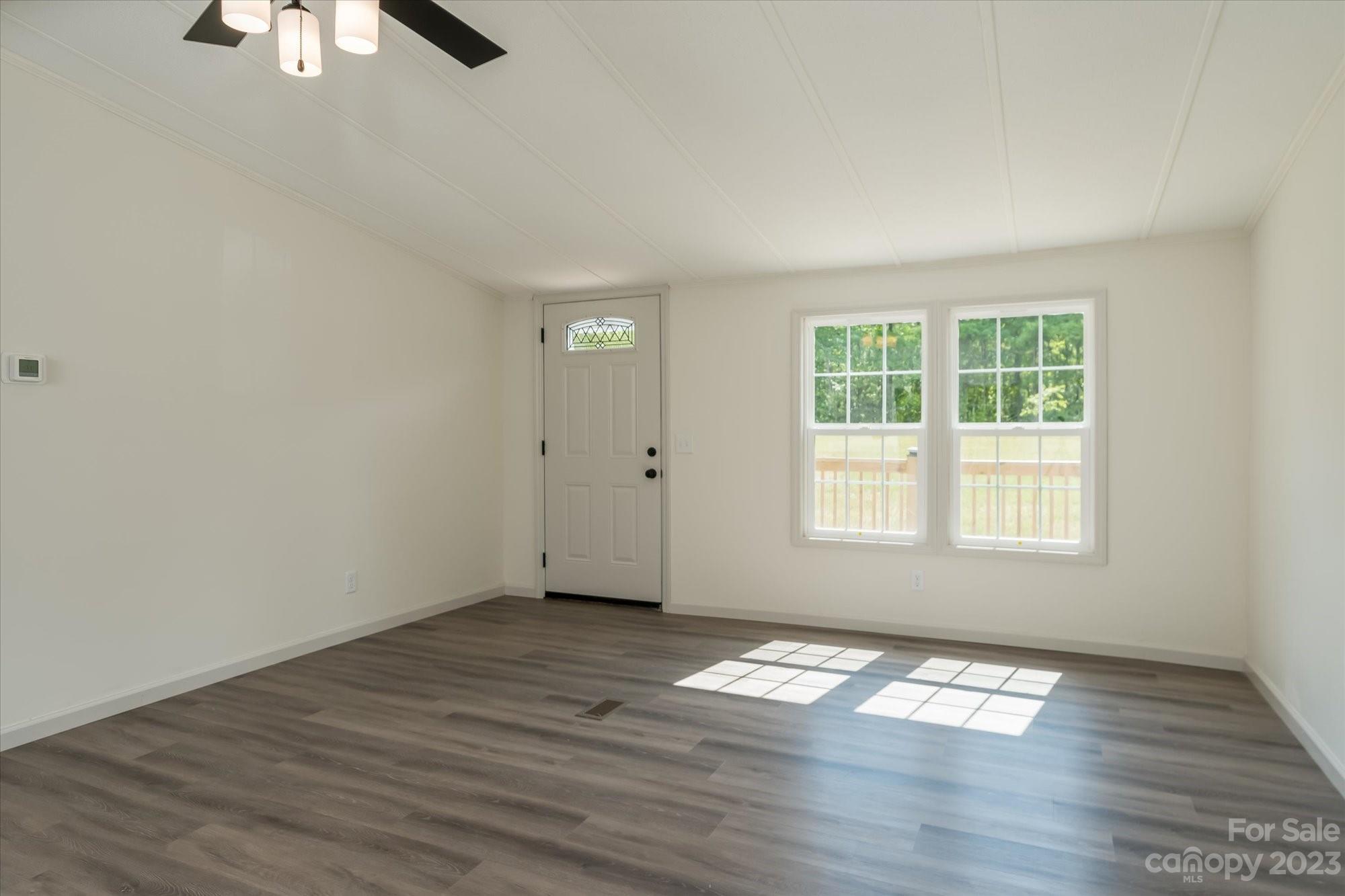 175 King Stepp Road Mill Spring, NC 28756 - Photo 13 of 46 an empty room with wooden floor cabinet and windows