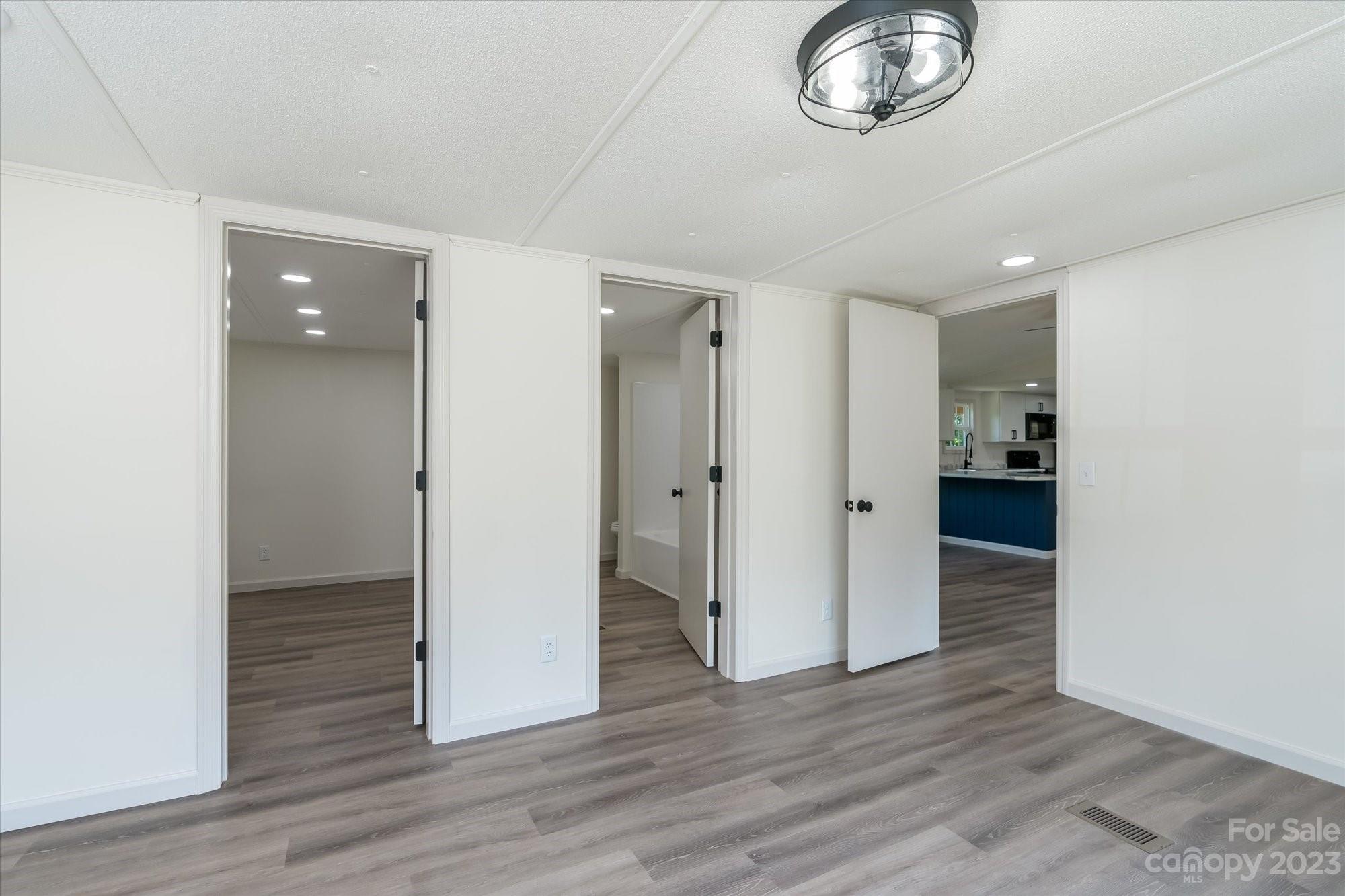 175 King Stepp Road Mill Spring, NC 28756 - Photo 18 of 46 an empty room with wooden floor and windows