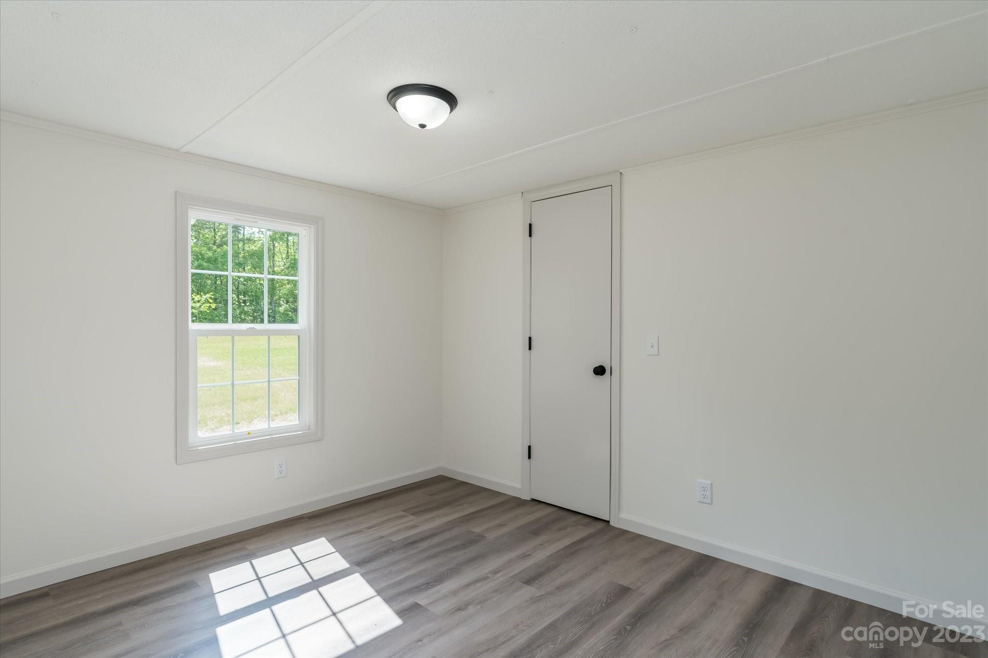 175 King Stepp Road Mill Spring, NC 28756 - Photo 21 of 46 an empty room with wooden floor and windows