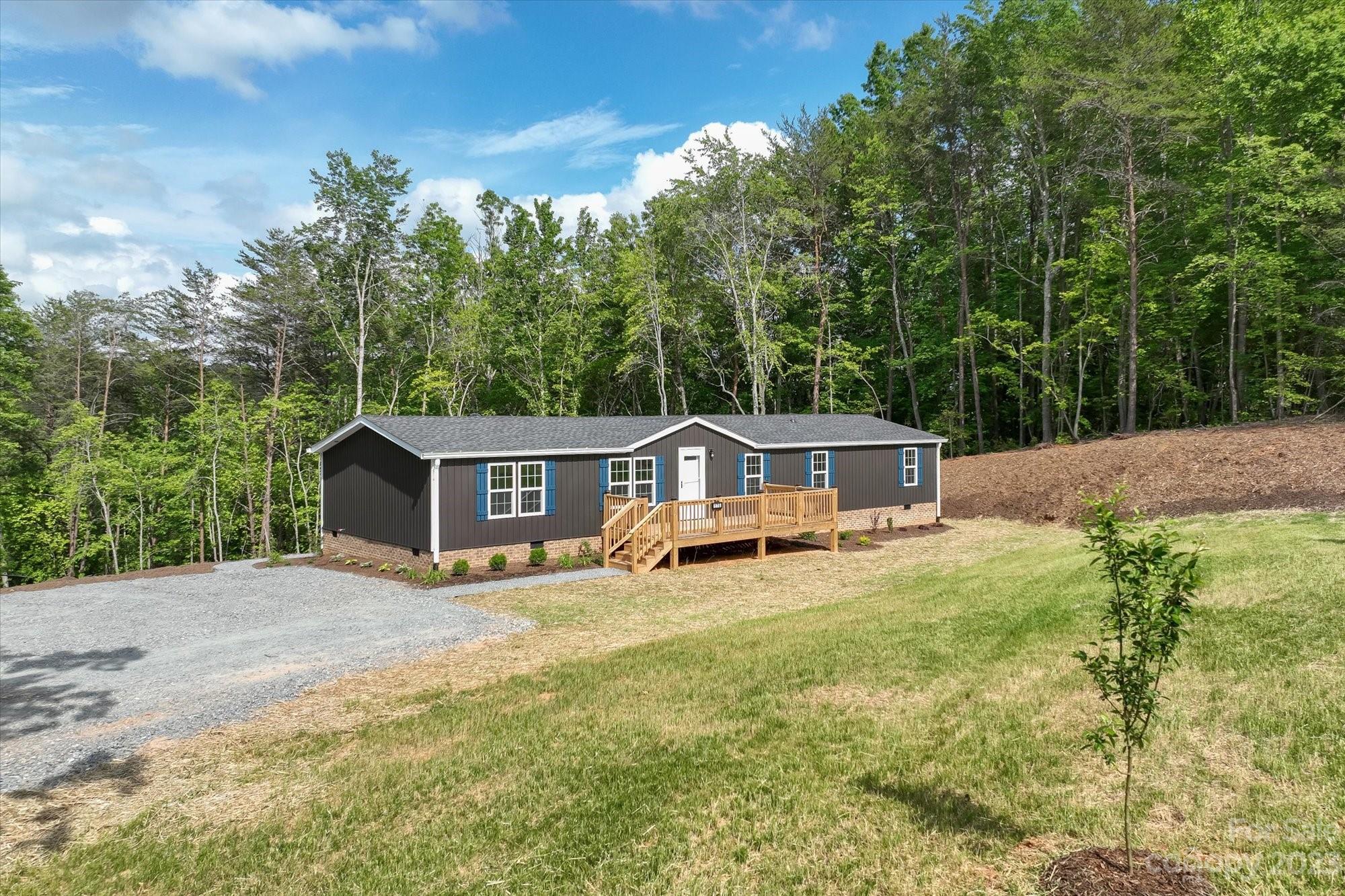 175 King Stepp Road Mill Spring, NC 28756 - Photo 3 of 46 a view of a house with a yard and large trees