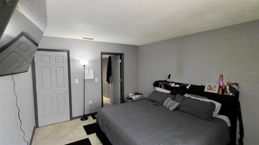 2938 Clark Road, Unit 203 Sarasota, FL 34231 - Photo 11 of 13 a bed room with a bed and a mirror