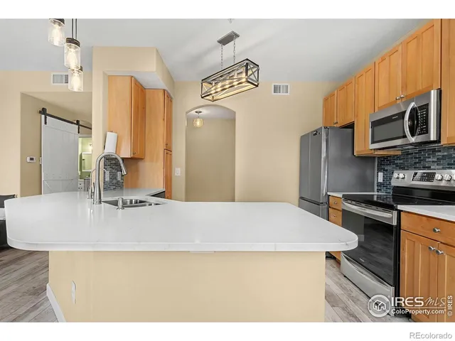 a kitchen with kitchen island a sink appliances and cabinets