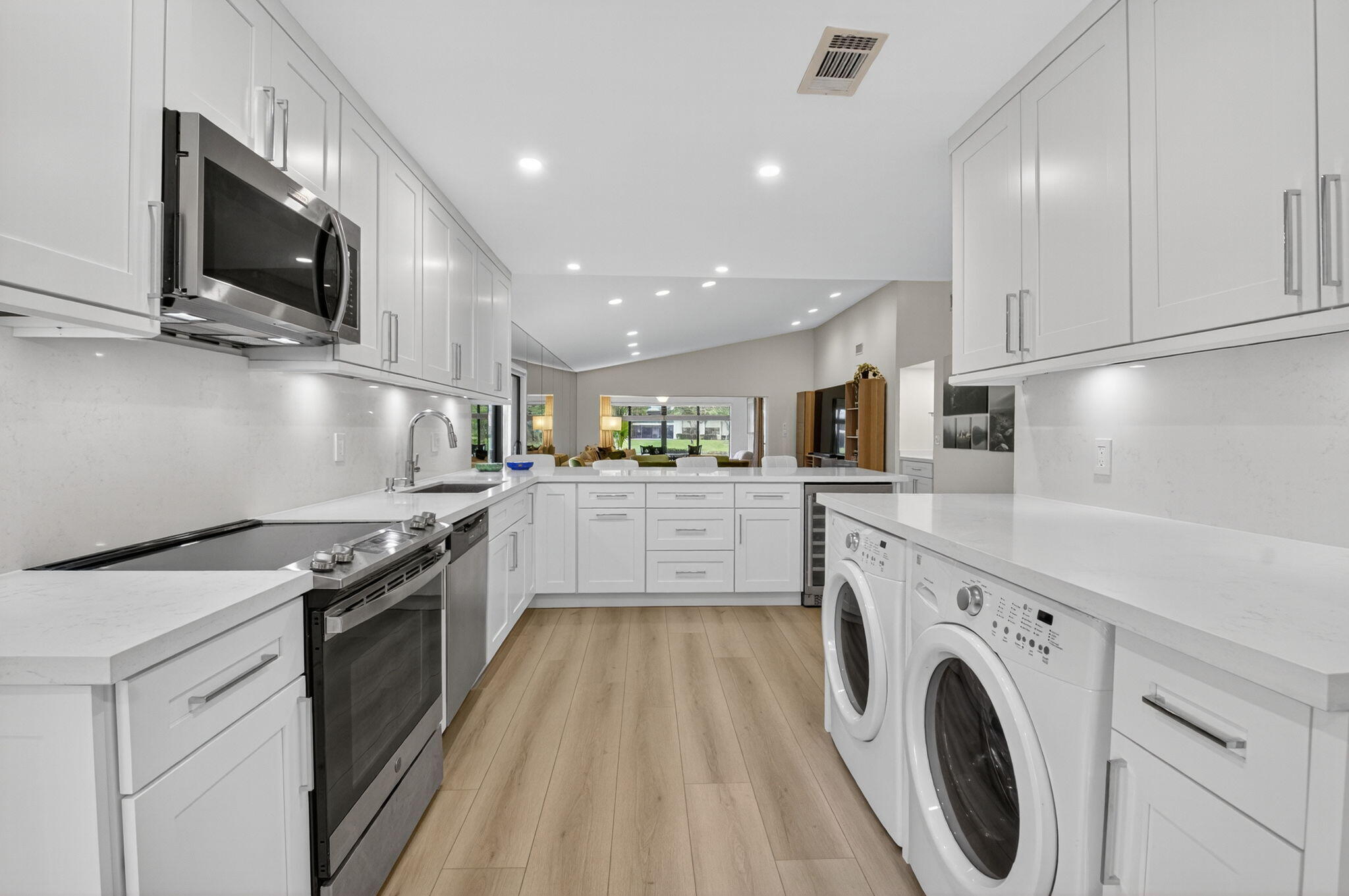 24 Westgate Lane, Unit A Boynton Beach, FL 33436 - Photo 22 of 94 a kitchen with granite countertop a sink a stove top oven and cabinetry