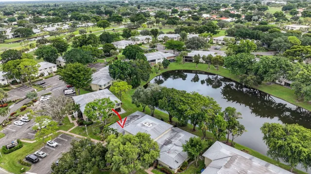a sign of golf club on a wall under a tree