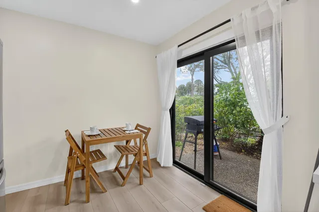 a living room with furniture flat screen tv and large window
