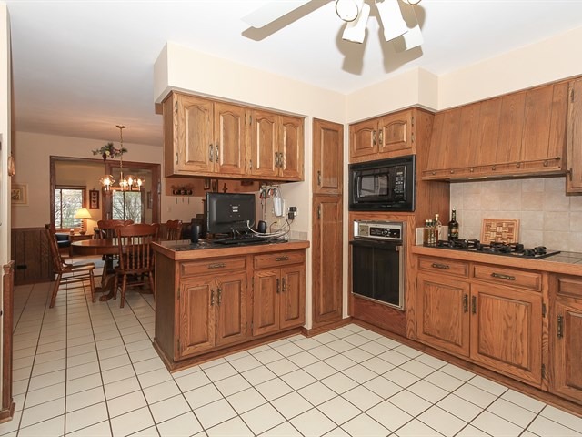 27 Green Ridge Road Elgin, IL 60120 - Photo 8 of 21 a kitchen with stainless steel appliances granite countertop a stove top oven a sink dishwasher a dining table and chairs with wooden floor