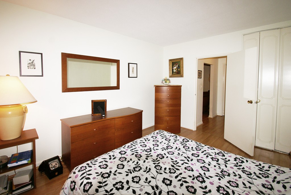 112 Lake Shore Road, Unit 3 Boston, MA 02135 - Photo 4 of 9 a bedroom with a bed and a lamp on dresser
