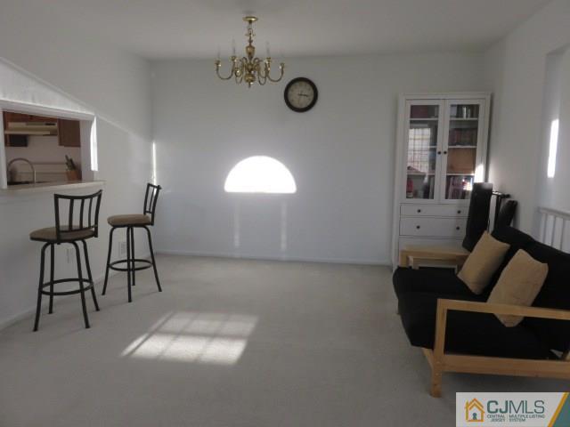 5006 Stonehedge Road Edison, NJ 08820 - Photo 5 of 14 a living room with furniture and a chandelier
