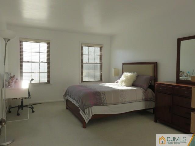 5006 Stonehedge Road Edison, NJ 08820 - Photo 7 of 14 a bed sitting in a bedroom next to a window
