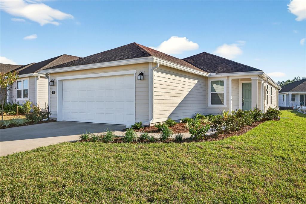 91 Tea Olive Drive Palm Coast, FL 32137 - Photo 2 of 18 a front view of house with garden