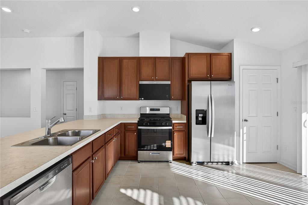 91 Tea Olive Drive Palm Coast, FL 32137 - Photo 7 of 18 a kitchen with granite countertop a sink stainless steel appliances and cabinets