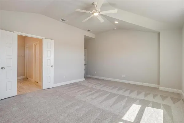 an empty room with an entryway and chandelier fan