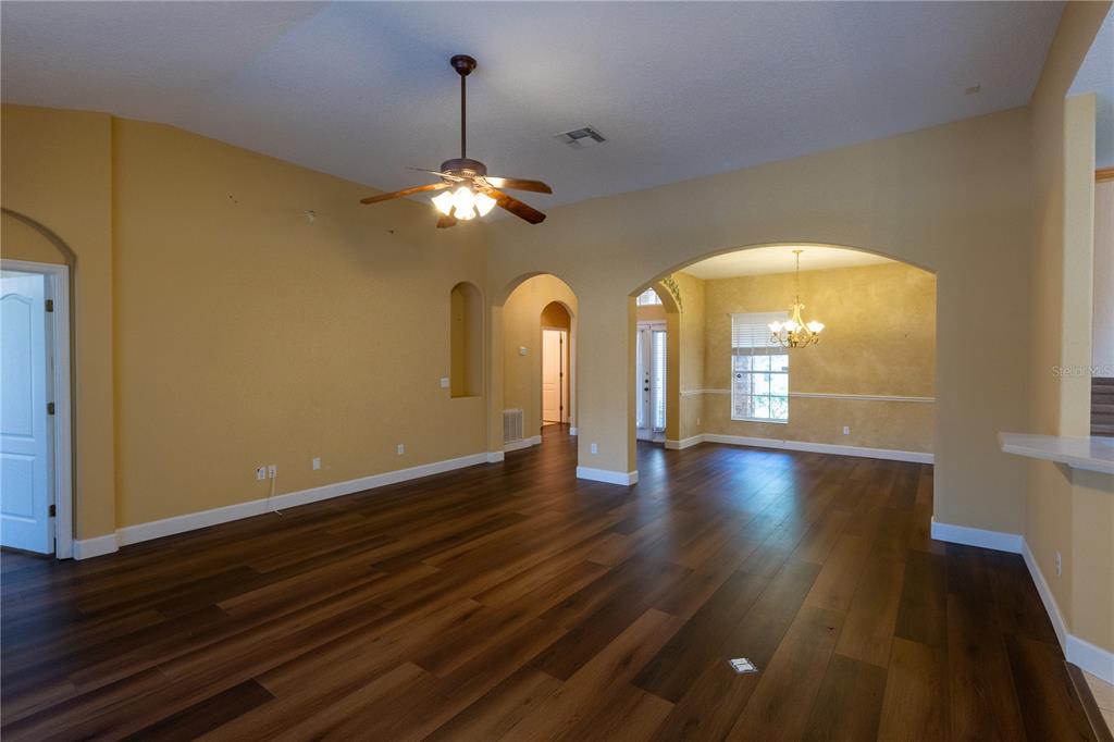 65 Calliope Street Ocoee, FL 34761 - Photo 10 of 60 a view of empty room with wooden floor and chandelier