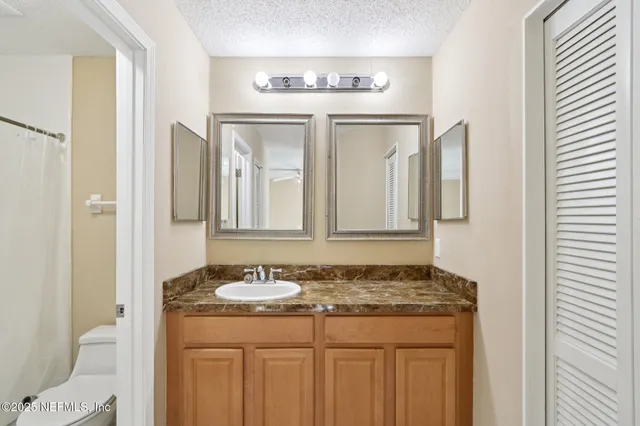 a bathroom with a granite countertop sink and a mirror