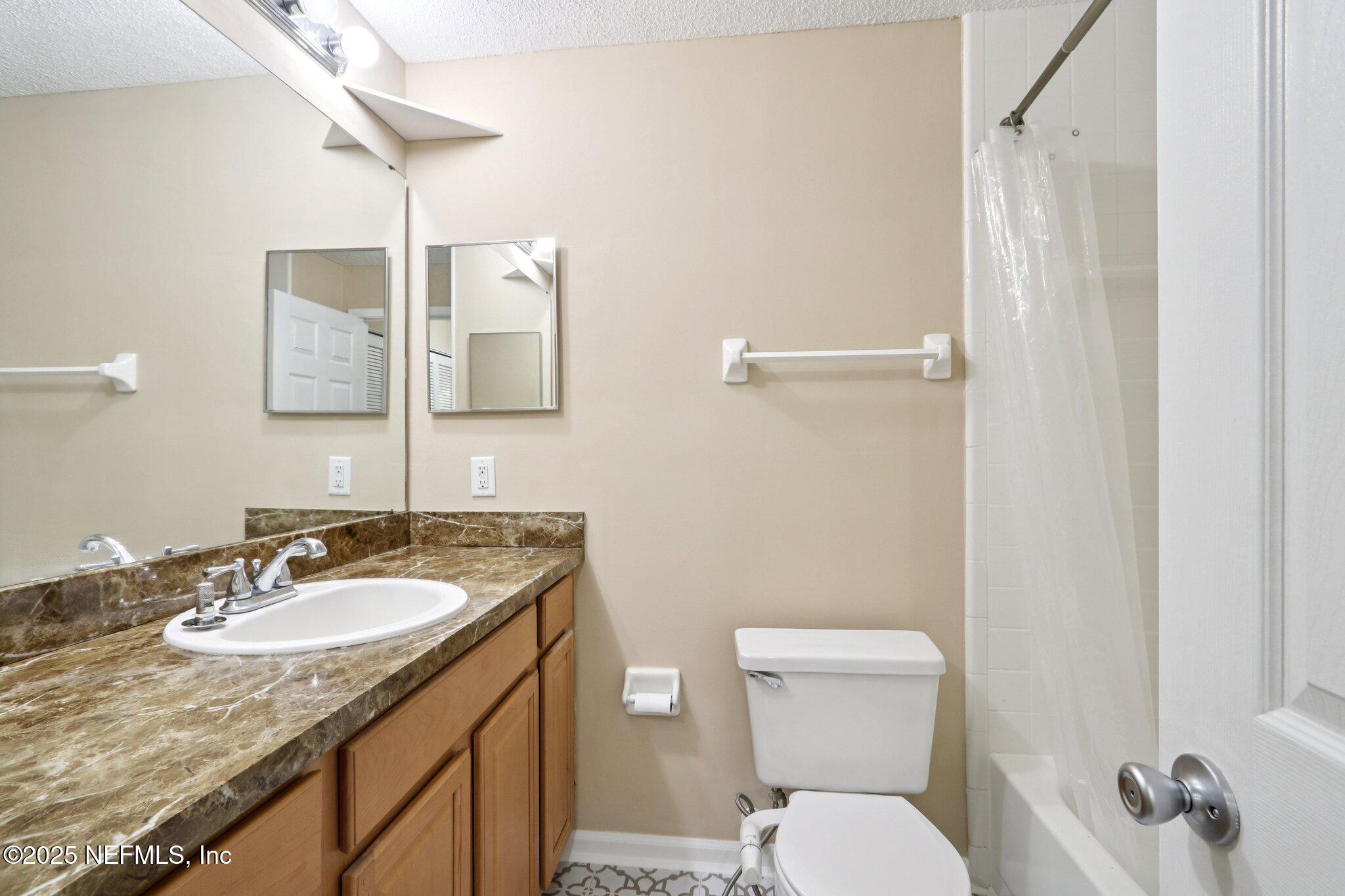 3801 Crown Point Road, Unit 2212 Jacksonville, FL 32257 - Photo 15 of 25 a bathroom with a granite countertop sink toilet and mirror