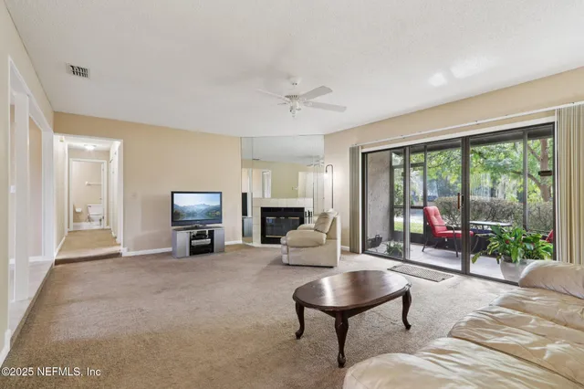 a living room with furniture and a floor to ceiling window
