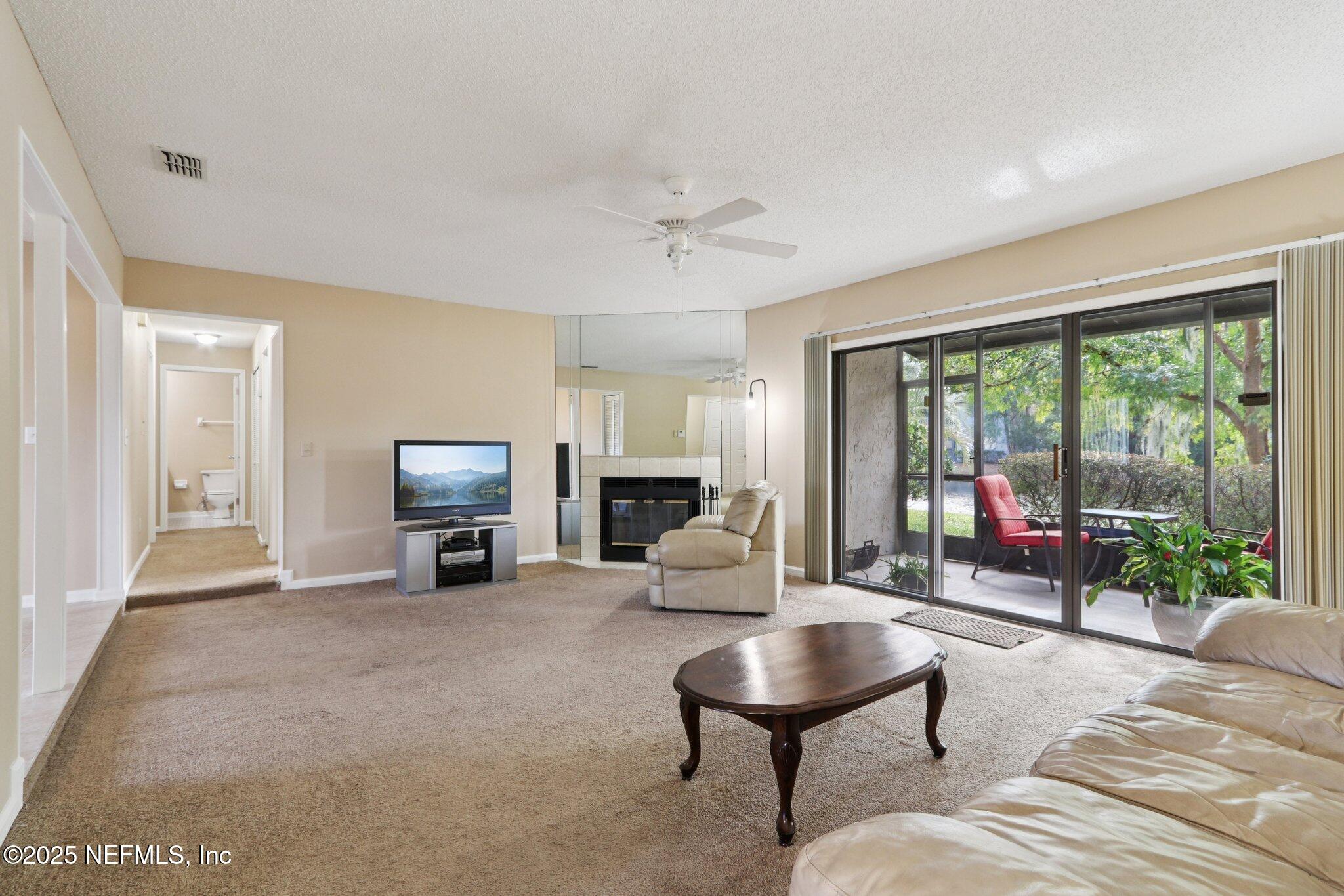 3801 Crown Point Road, Unit 2212 Jacksonville, FL 32257 - Photo 4 of 25 a living room with furniture and a floor to ceiling window