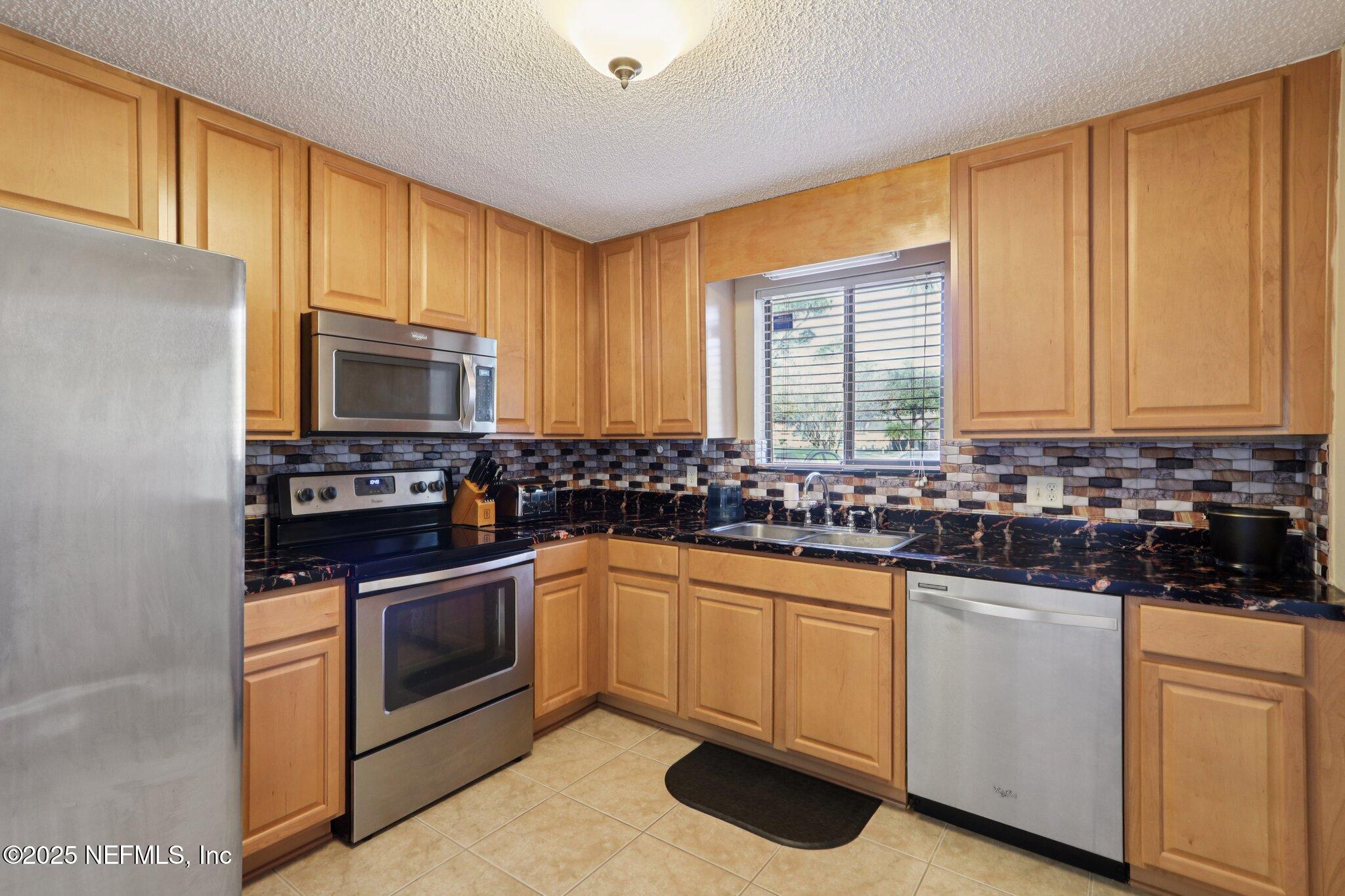 3801 Crown Point Road, Unit 2212 Jacksonville, FL 32257 - Photo 7 of 25 a kitchen with white cabinets and white appliances