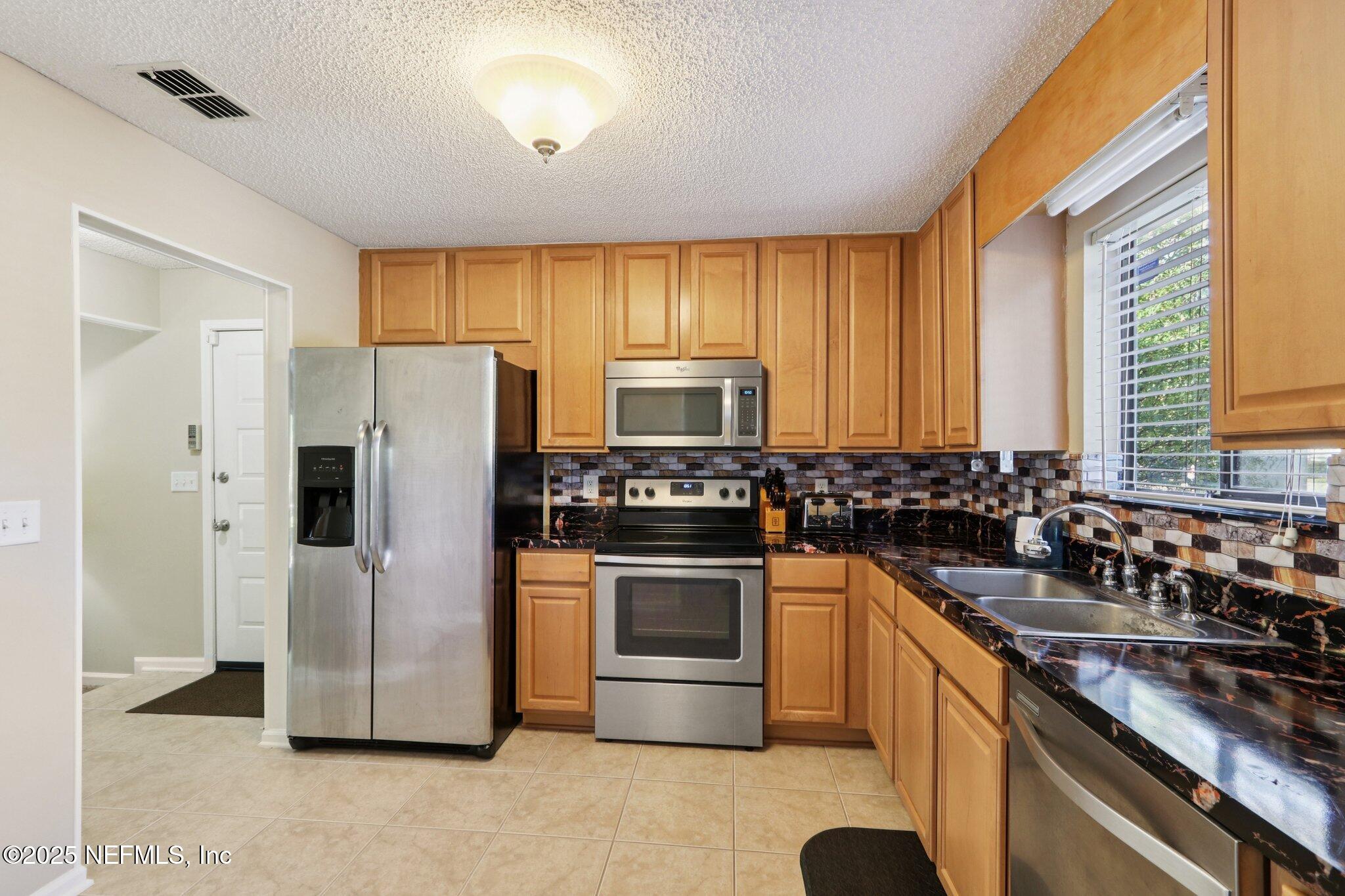 3801 Crown Point Road, Unit 2212 Jacksonville, FL 32257 - Photo 8 of 25 a kitchen with a sink stove and refrigerator