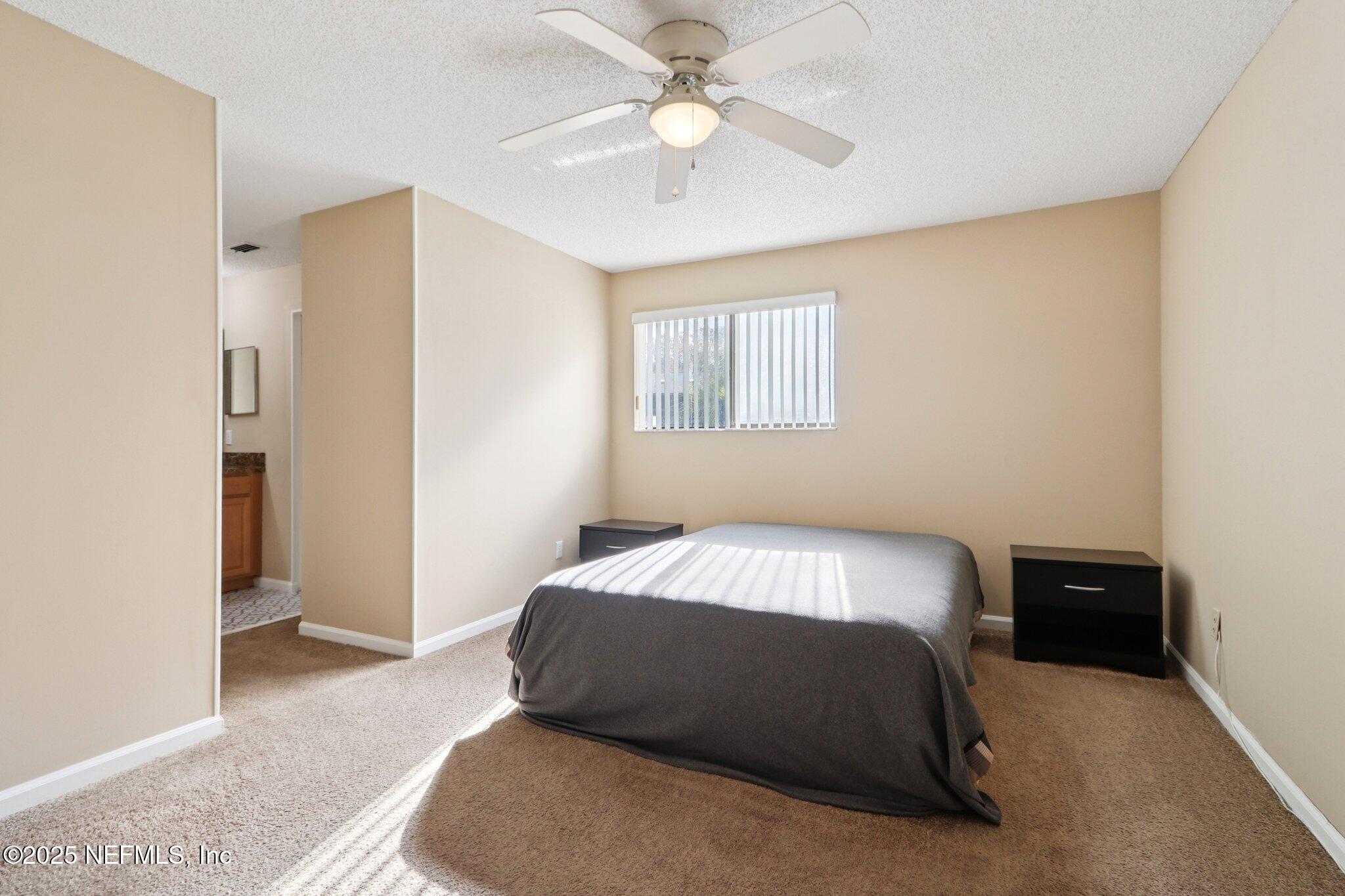 3801 Crown Point Road, Unit 2212 Jacksonville, FL 32257 - Photo 9 of 25 a bedroom with a bed and a chandelier