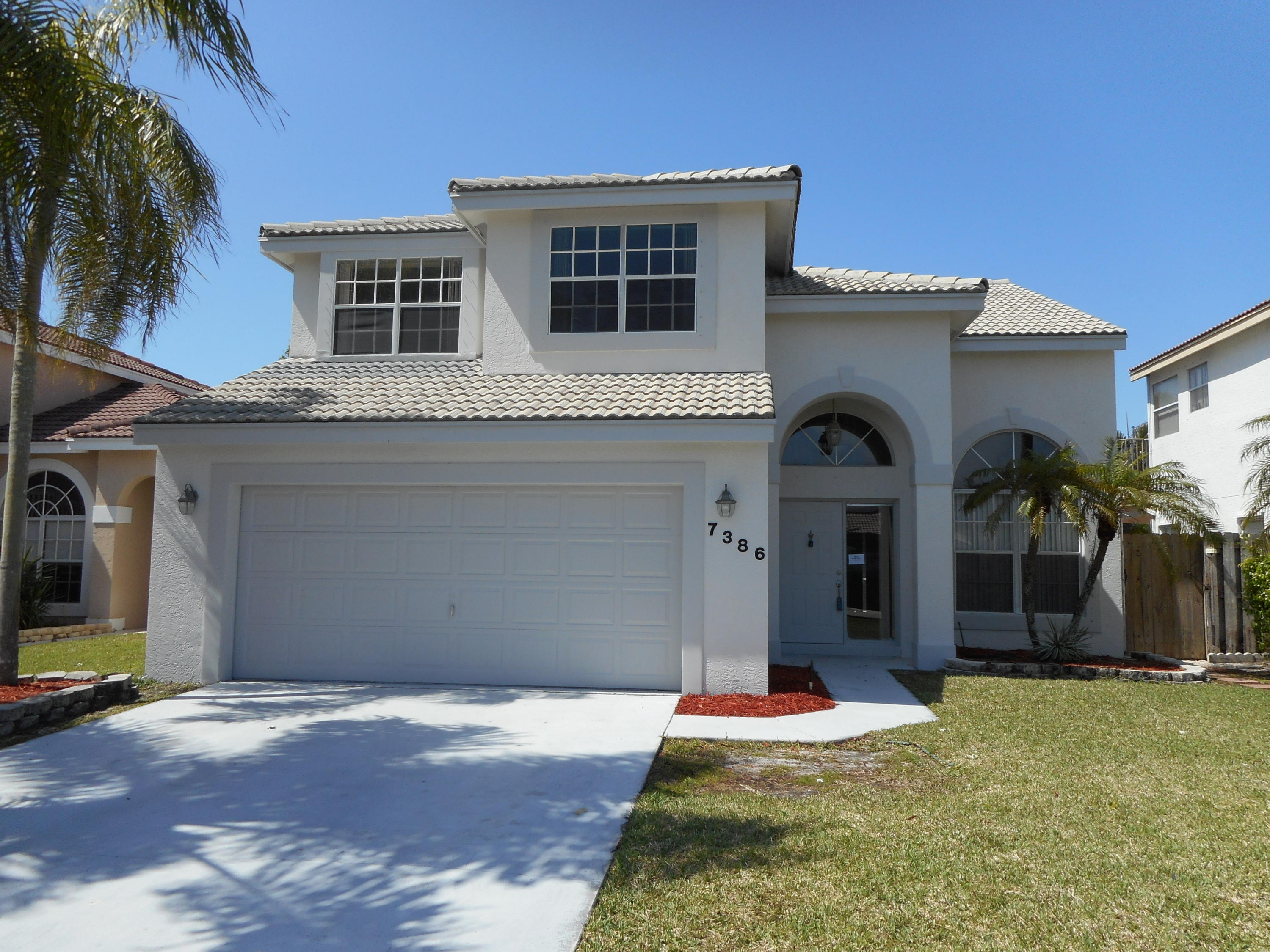 7386 Michigan Isle Road Lake Worth, FL 33467 - Photo 1 of 24 a front view of house with yard