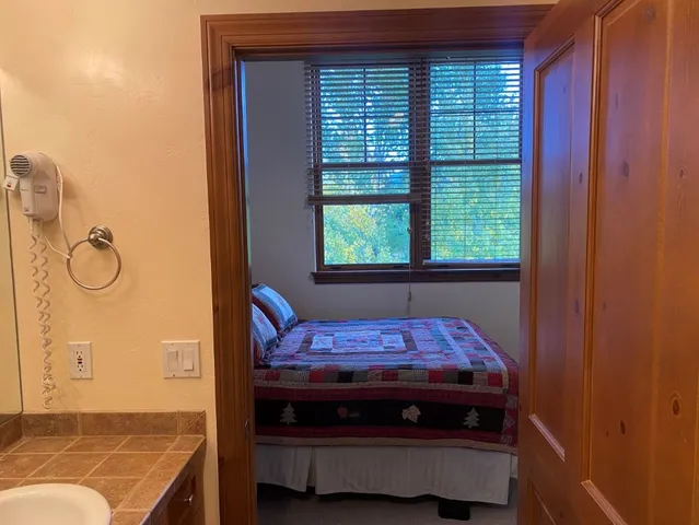 a bed sitting in a bedroom next to a window