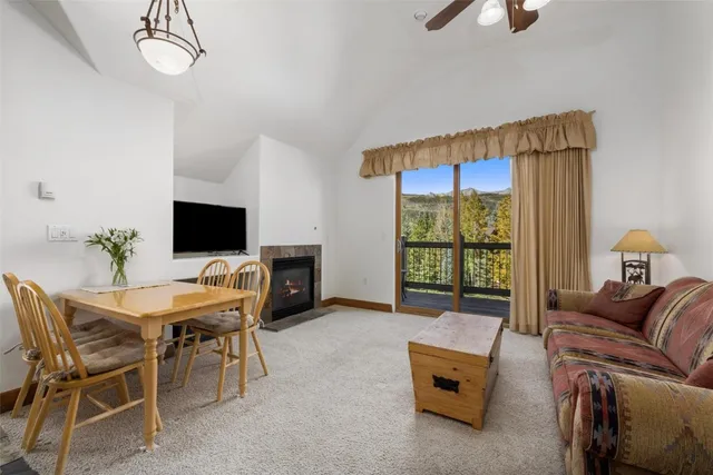 a living room with furniture a flat screen tv and a floor to ceiling window