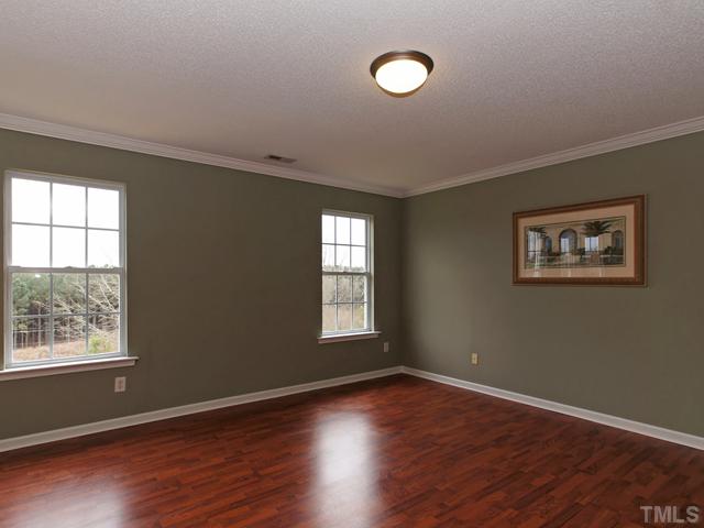740 Rockville Road Wake Forest, NC 27587 - Photo 13 of 25 an empty room with wooden floor and windows