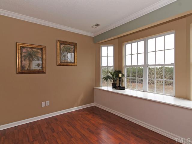 740 Rockville Road Wake Forest, NC 27587 - Photo 14 of 25 an empty room with wooden floor and windows