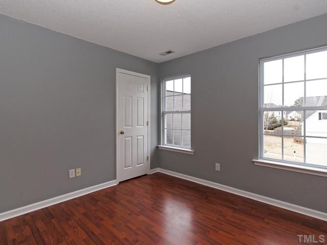 740 Rockville Road Wake Forest, NC 27587 - Photo 16 of 25 an empty room with wooden floor and windows