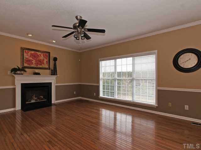740 Rockville Road Wake Forest, NC 27587 - Photo 4 of 25 a view of an empty room with wooden floor and a fireplace