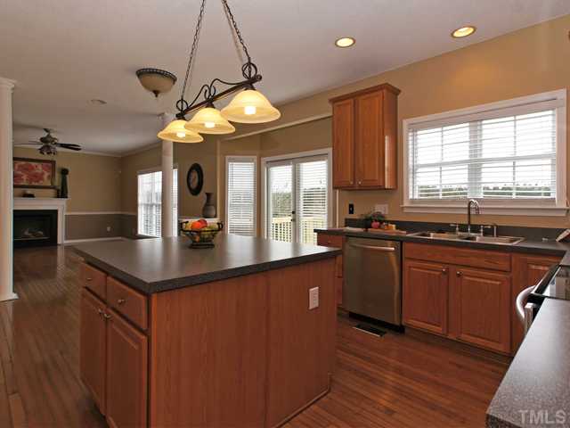 740 Rockville Road Wake Forest, NC 27587 - Photo 7 of 25 a kitchen with stainless steel appliances granite countertop a sink a stove and a wooden floors