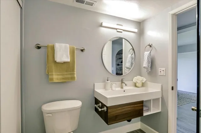 a bathroom with a toilet sink and mirror