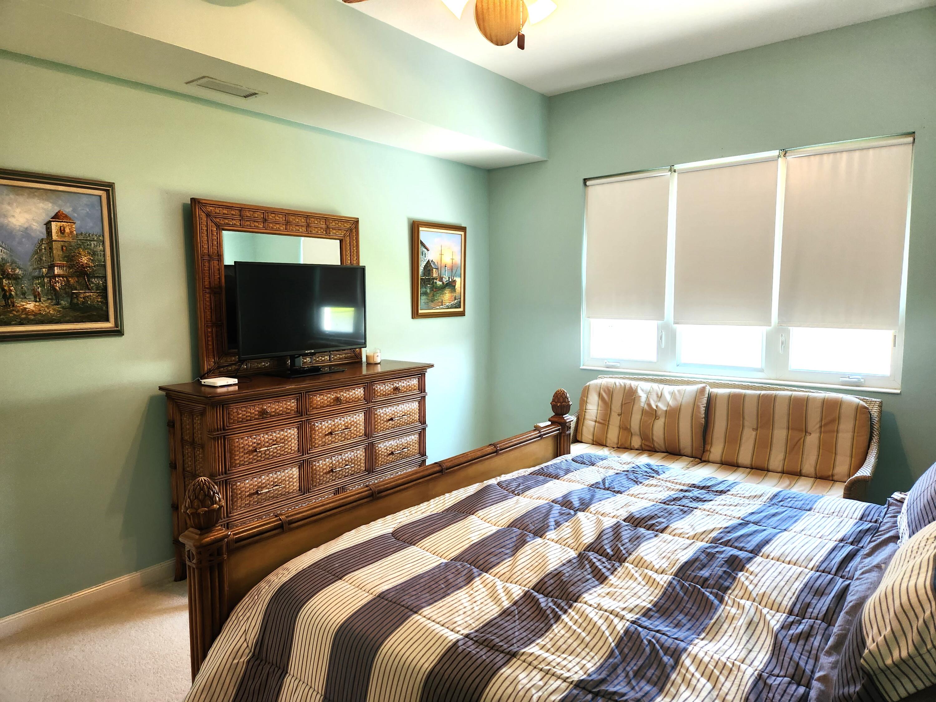 1 Harbour Isle Drive East, Unit 104 Fort Pierce, FL 34949 - Photo 14 of 28 a bedroom with a bed and a flat screen tv