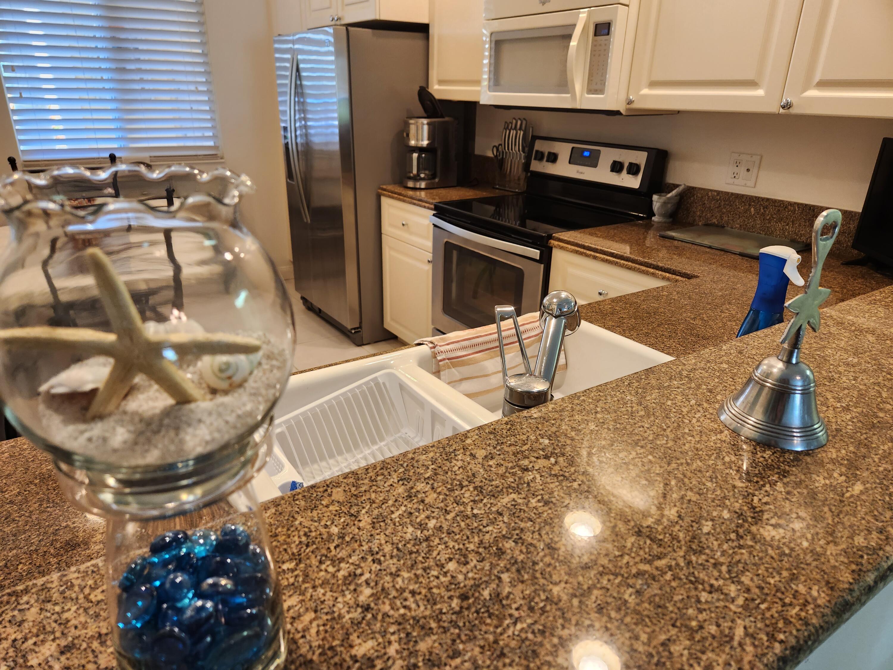 1 Harbour Isle Drive East, Unit 104 Fort Pierce, FL 34949 - Photo 25 of 28 a kitchen with a sink and a stove