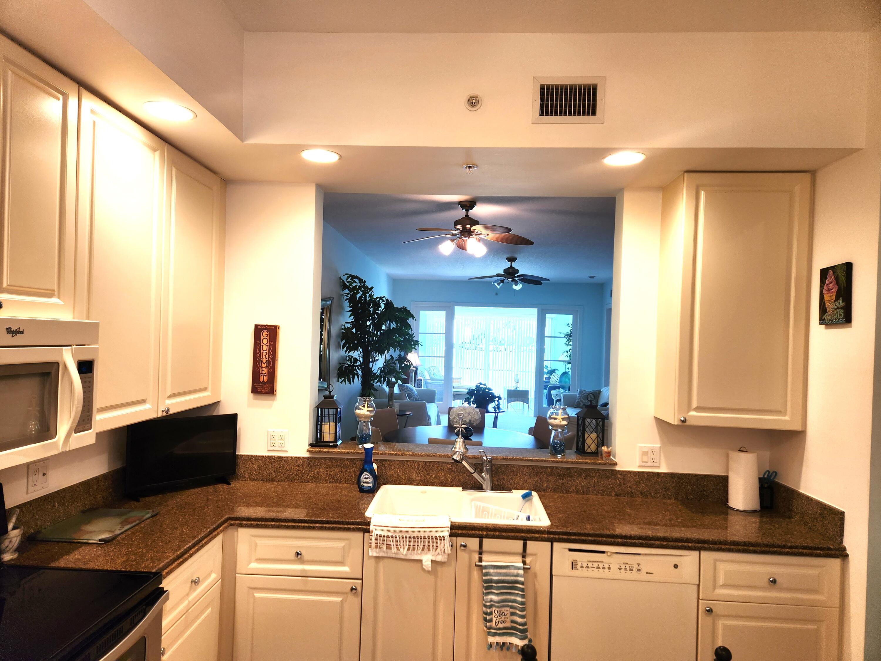 1 Harbour Isle Drive East, Unit 104 Fort Pierce, FL 34949 - Photo 6 of 28 a kitchen with stainless steel appliances granite countertop a sink stove and cabinets