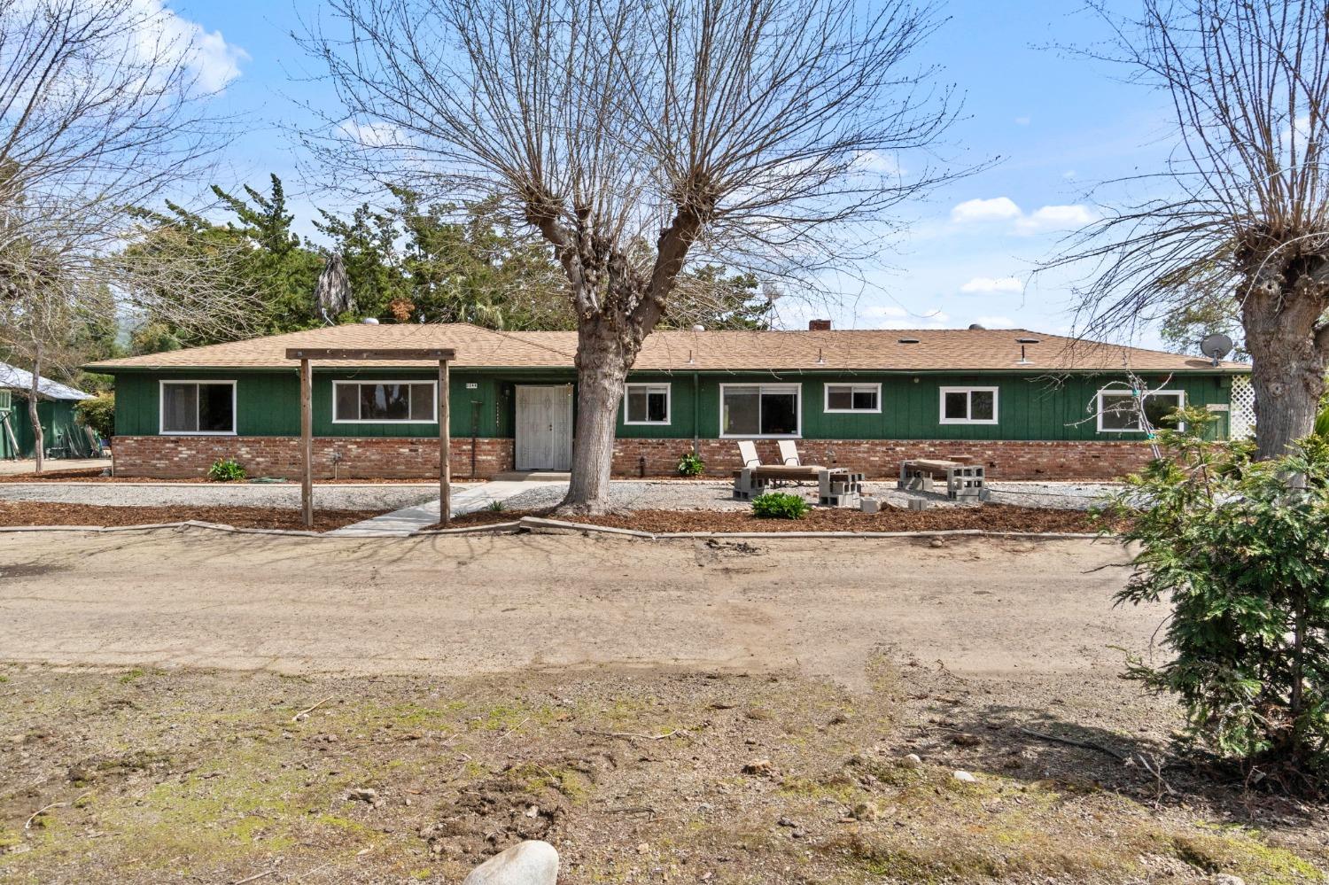 2244 Tivy Valley Road Sanger, CA 93657 - Photo 1 of 44 a front view of a building with a yard and large tree