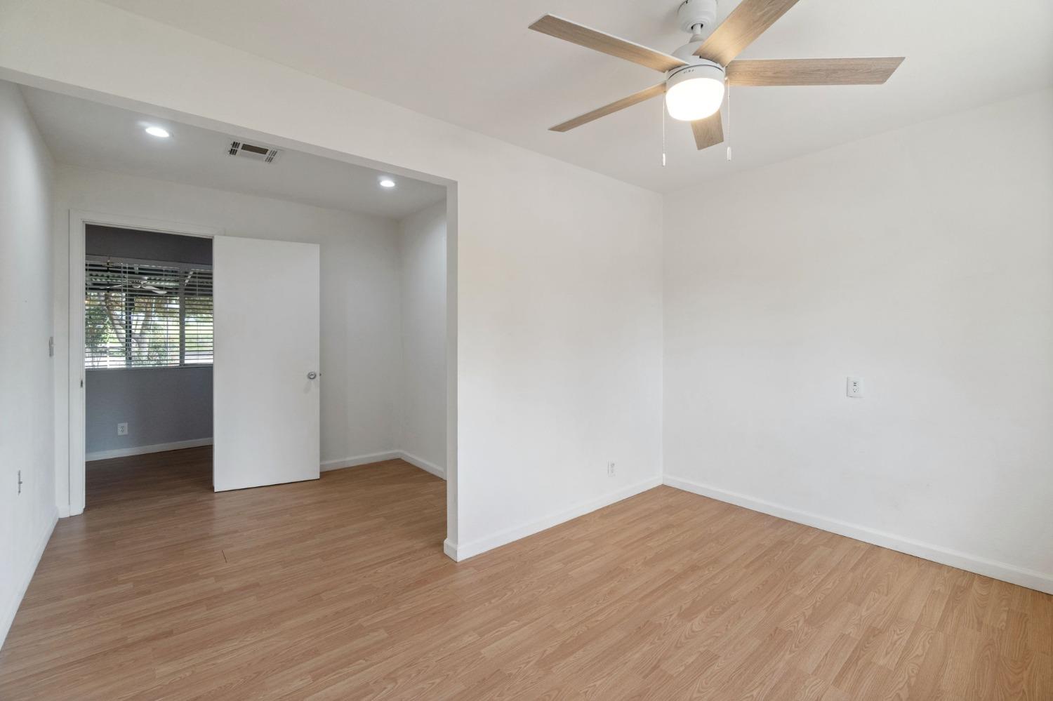 2244 Tivy Valley Road Sanger, CA 93657 - Photo 18 of 44 an empty room with wooden floor chandelier fan and closet area