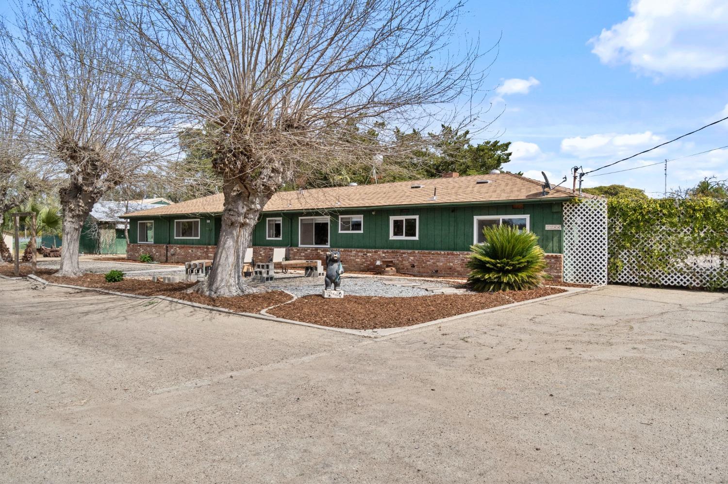 2244 Tivy Valley Road Sanger, CA 93657 - Photo 2 of 44 a front view of a house with a garden and trees