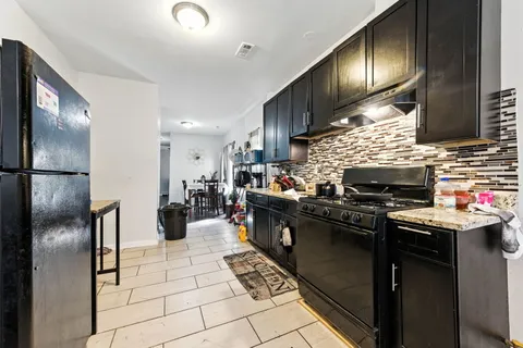 a kitchen with stainless steel appliances granite countertop a stove a sink dishwasher and a refrigerator