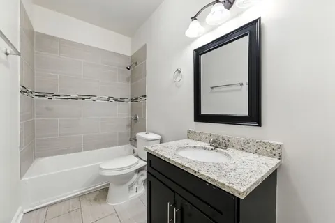 a bathroom with a granite countertop sink toilet and shower