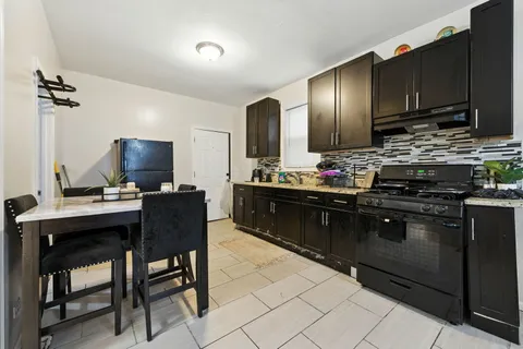 a kitchen with stainless steel appliances granite countertop a sink wooden cabinets and a stove top oven