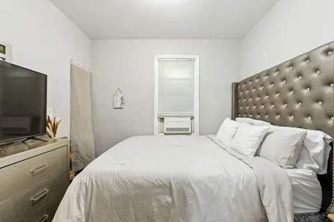 a bedroom with a bed and a flat screen tv