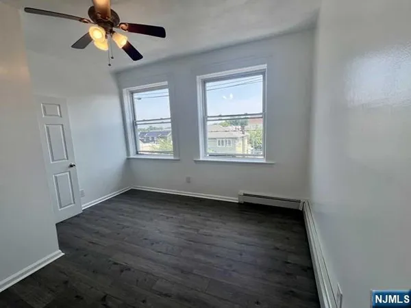 a view of an empty room window and wooden floor