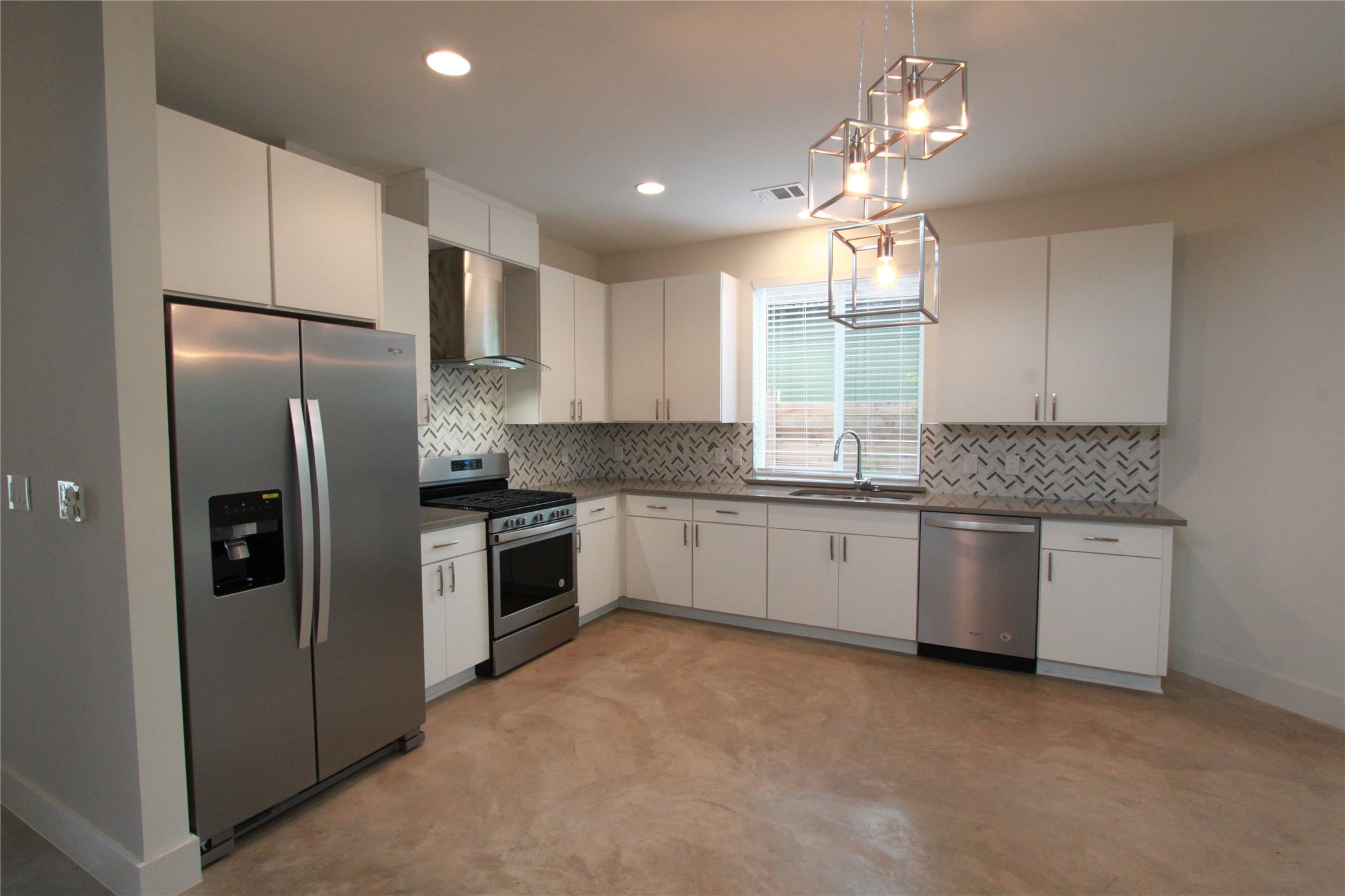 1204 Cometa Street, Unit A Austin, TX 78721 - Photo 12 of 38 Kitchen with stainless steel appliances, pendant lighting, and white cabinetry