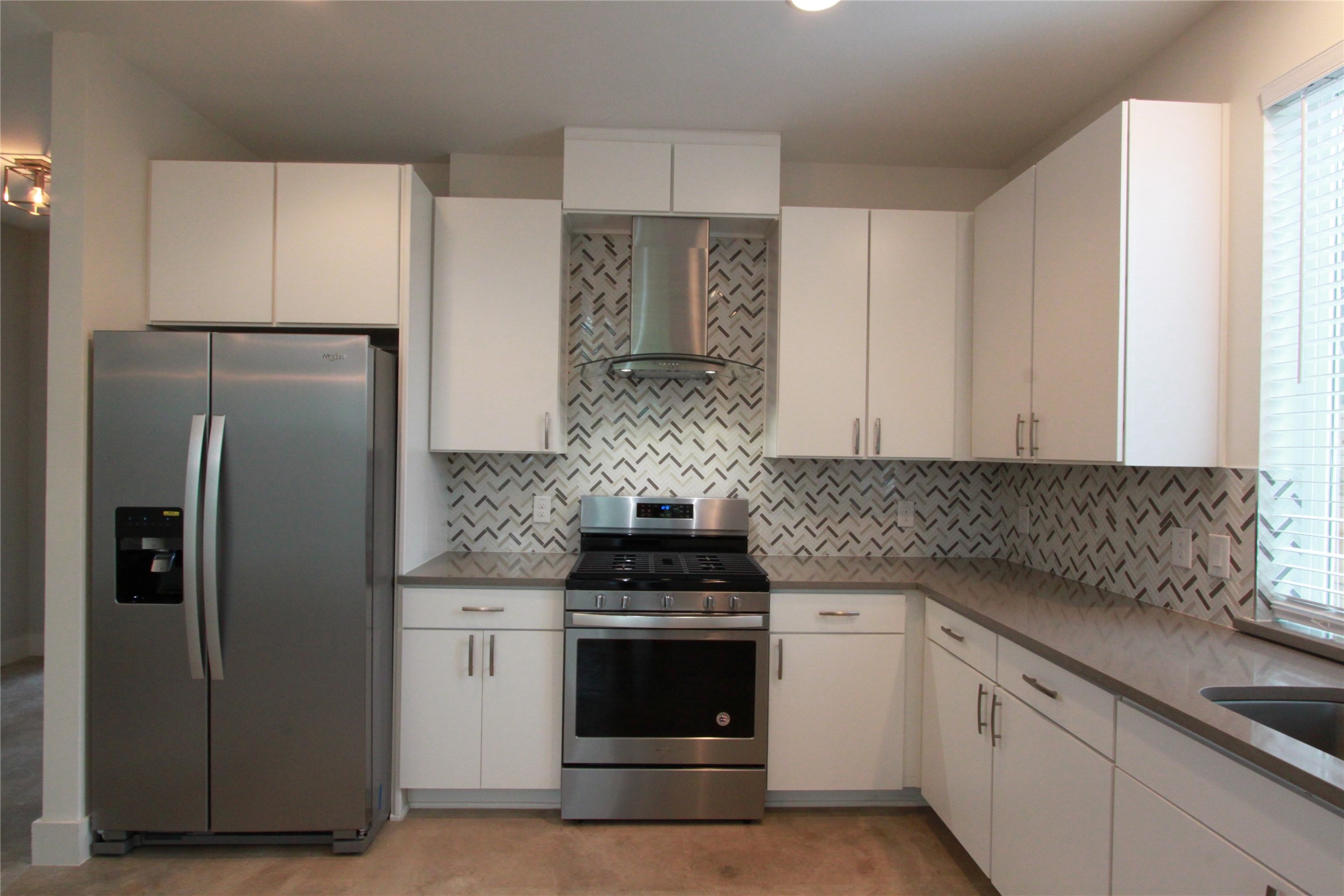1204 Cometa Street, Unit A Austin, TX 78721 - Photo 13 of 38 Kitchen with stainless steel appliances, white cabinetry, dark stone counters, and backsplash