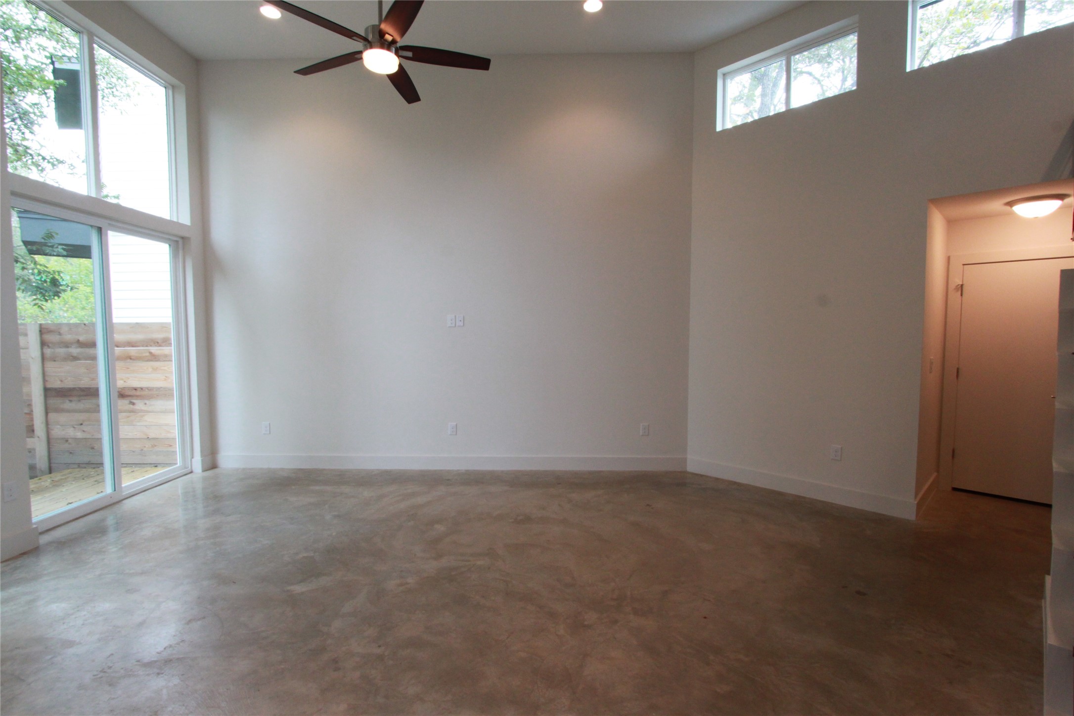 1204 Cometa Street, Unit A Austin, TX 78721 - Photo 6 of 38 Spare room featuring a high ceiling, finished concrete flooring, a ceiling fan, and recessed lighting