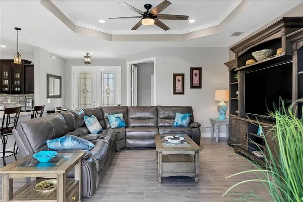 a living room with furniture a ceiling fan and a flat screen tv