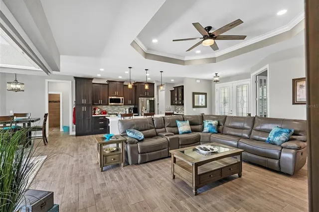 a living room with furniture kitchen view and a wooden floor